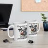 White ceramic mug with a cartoon cow wearing glasses and chewing grass, text says