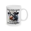 A white ceramic mug with a humorous image of a cow wearing glasses and eating grass, with text that reads 