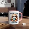 White ceramic mug with a pink rim and handle, featuring a cute sloth holding a coffee cup with "Busy Doing Nothing" text.