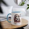 Cute sloth holding a coffee cup that says 'first coffee', sitting in a chair. White mug with blue interior and handle.