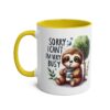 White ceramic mug with a yellow interior and handle, featuring a cartoon sloth drinking from a cup.