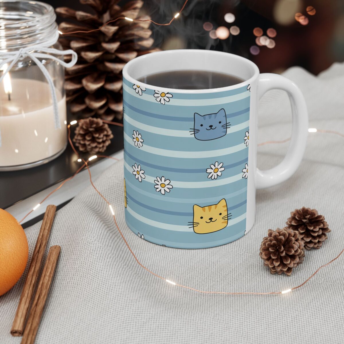 White ceramic mug with blue stripes and cute cat and daisy designs.
