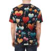 Back view of a person wearing a dark t-shirt with a repeating pattern of stylized heart-shaped flowers in vibrant colors like red, orange, yellow, and blue, accented with green leaves and small floral elements.