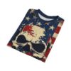 A folded t-shirt features a distressed American flag pattern and a prominent skull graphic in cream, red, and dark blue on a white background.