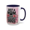 Ceramic coffee mug with navy blue handle and rim, featuring text 'JUST A MOM WHO RESCUES DOGS' and floral graphic.