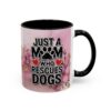 Ceramic mug featuring 'Just A Mom Who Rescues Dogs' text with paw print and heart graphics on a floral background.