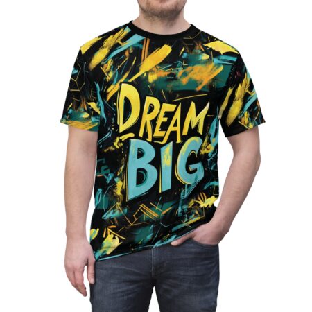 Teal, yellow, and black paint splatters cover this graphic streetwear tee, depicting a bold Dream Big graffiti print.