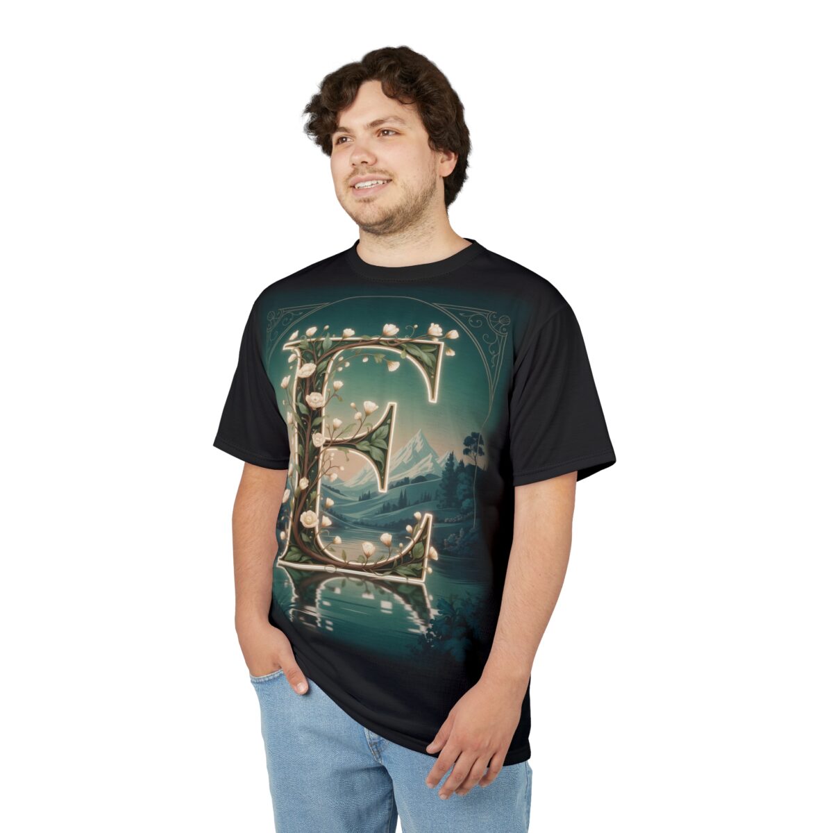 Emerald greens, glowing whites, and earthy browns cover this patterned tee shirt, depicting a stylized letter 'E' adorned with flowers and set against a serene landscape.