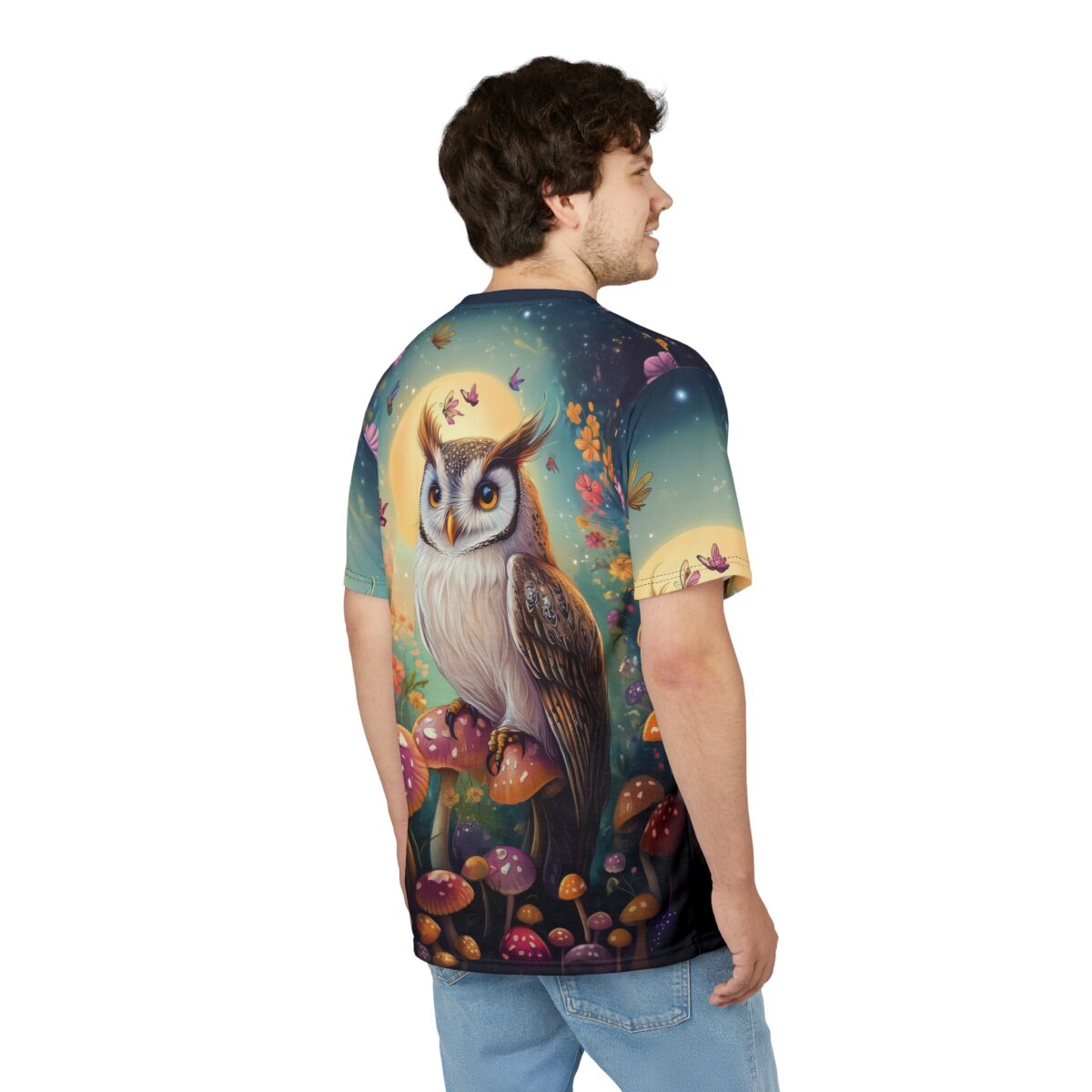 A regal owl perched on mushrooms beneath a glowing moon, with butterflies and flowers scattered across the dark, starry sky of this patterned tee shirt.