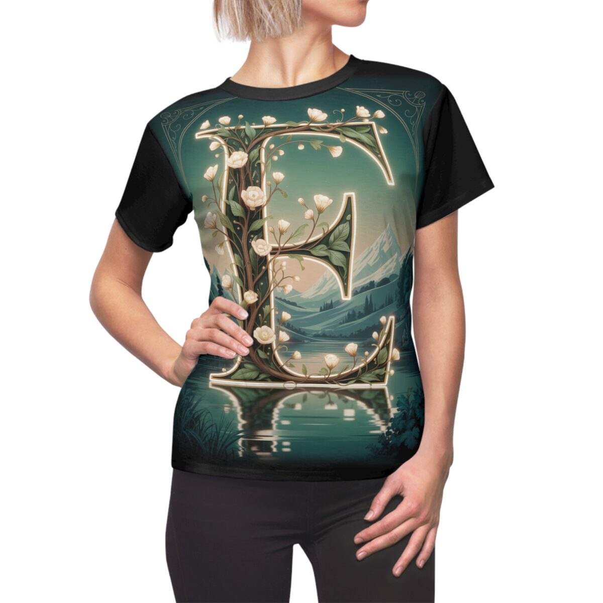 All over print sublimation tee showcasing a large floral letter 'E' set against a serene landscape with mountains and a lake.
