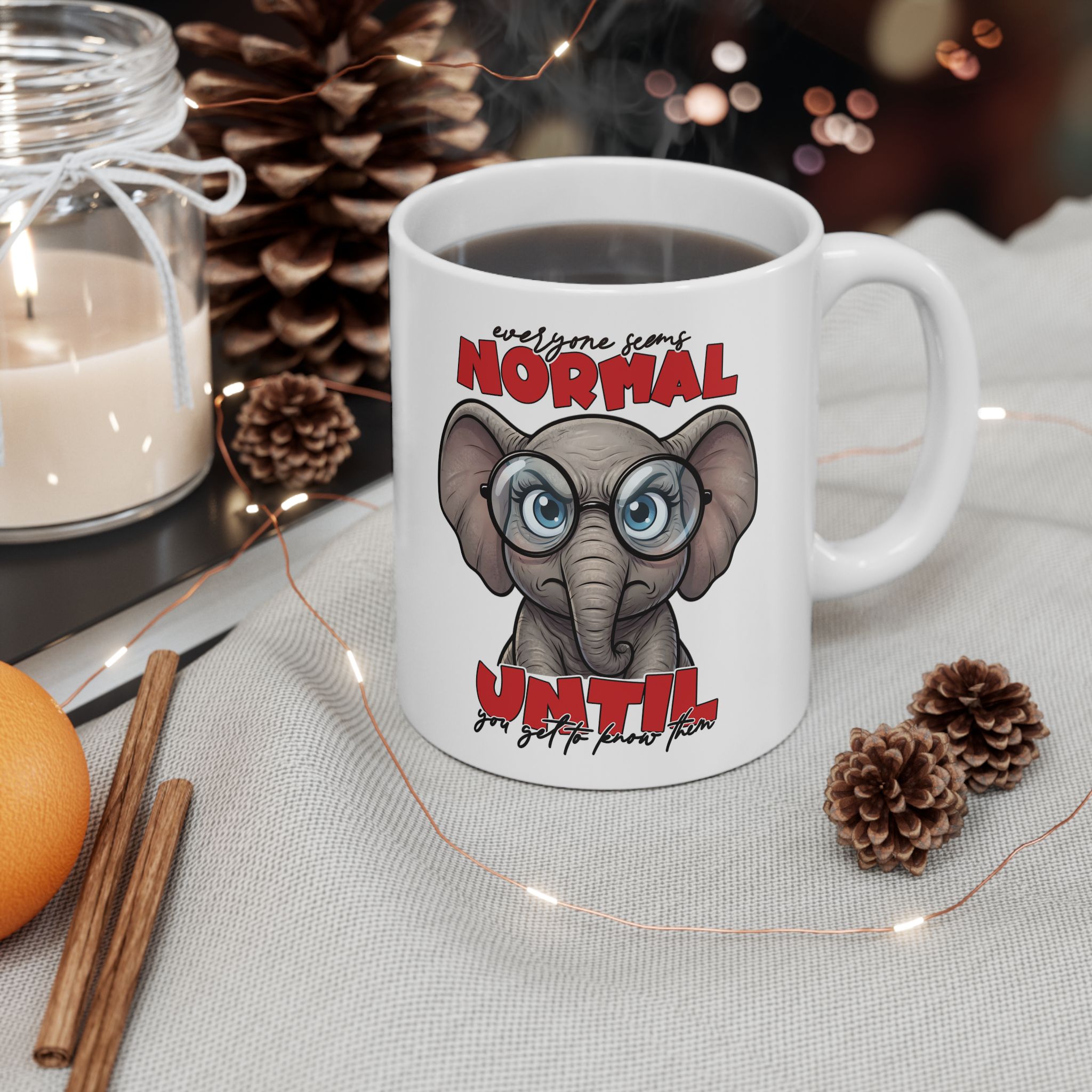White mug with a cartoon elephant wearing glasses and the text "Everyone seems normal until you get to know them."