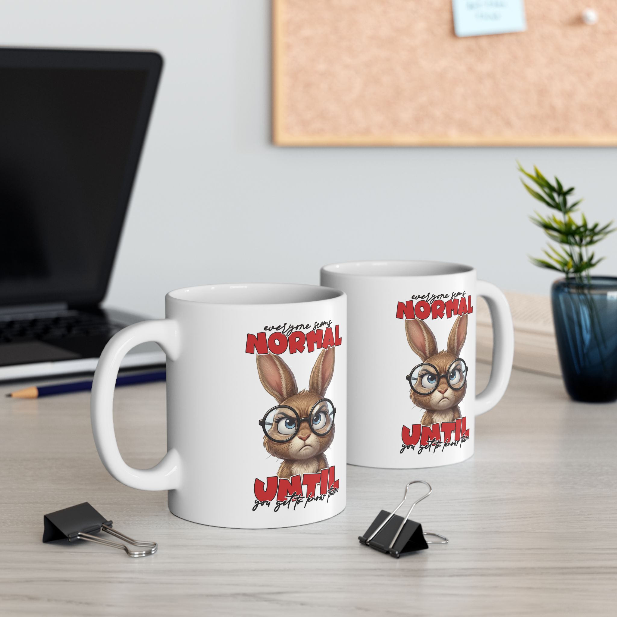 Two white ceramic coffee mugs with a sarcastic rabbit illustration and text.