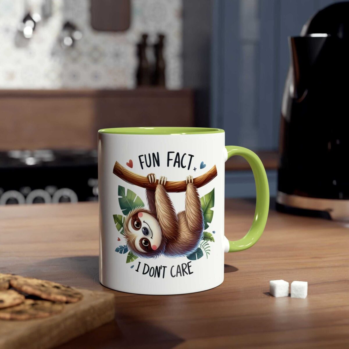 White ceramic mug with a green handle and rim, featuring a sloth illustration with text.