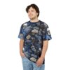 Man wearing a dark blue t-shirt with a skull and floral design against a white background.