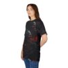 A young woman wearing a black t-shirt with a gothic design featuring multiple skulls with glowing red eyes intertwined with dark, thorny branches and hints of fiery red flames.