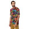 Vibrant pink, orange, yellow, blue graffiti shapes, cartoonish robot faces cover this patterned tee shirt.
