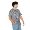 Black and white paw prints and fish bones cover this gray patterned tee shirt, with small white dots scattered throughout.