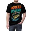 Orange and teal text, a splashing bass, and stars cover this patterned tee shirt with a bold fishing vibe.