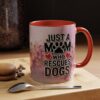 Ceramic mug with 'Just A Mom Who Rescues Dogs' text, paw print, and heart graphics on a pink marble background with floral accents.