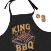 Black apron with a graphic of ribs on a spatula under the text 'KING OF THE BBQ'.