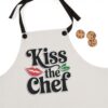 Chef apron with 'Kiss the Chef' text, red lips graphic, and green leaves. Perfect kitchen wear for culinary enthusiasts.