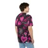 A man wearing a black t-shirt with a repeating pattern of pink and white hearts, seen from the back and side.