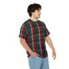 A man wearing a t-shirt with a red, teal, and white knitted pattern, standing with his hand in his pocket.