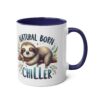 White ceramic mug with navy blue handle and interior, featuring a sleeping sloth on a branch and the text "NATURAL BORN CHILLER".