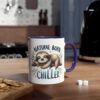 White ceramic mug with purple handle, featuring a sleepy sloth illustration and the words "Natural Born Chiller".