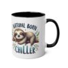 White ceramic mug with a black interior and handle, featuring a cartoon sloth hanging from a branch and the words "Natural Born Chiller."