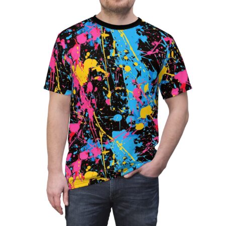 Vibrant pink, blue, and yellow paint splatters cover this graphic streetwear tee, set against a black background with white speckles.