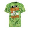 Green shamrocks cover this seamless pattern tee, showcasing the text Not Irish But Kiss Me Anyway across the chest.