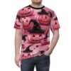 Pink pumpkins with carved faces and black witch hats with pink stars cover this tee shirt, with scattered black leaves.