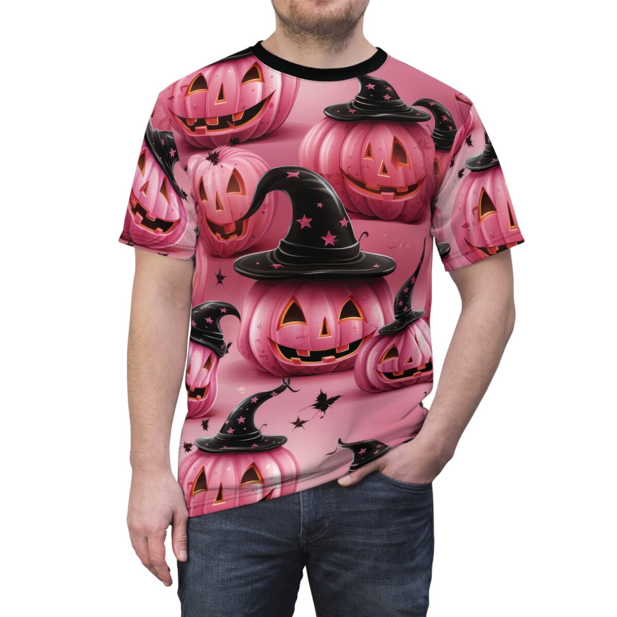 Pink pumpkins with carved faces and black witch hats with pink stars cover this tee shirt, with scattered black leaves.