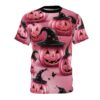 Pink pumpkins with black witch hats and pink stars cover this all over print tee, with a soft pink background and falling black leaves.