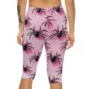 A person wears pink capri leggings featuring a pattern of black spiders with dark pink shadows on a light pink background.