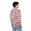Pink background with scattered skulls and floral patterns, including roses and tulips, in black and white.