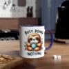 A white ceramic mug with a cute cartoon sloth holding a coffee cup, surrounded by flowers and text that says "BUSY DOING NOTHING".