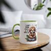 White ceramic mug with a green rim and handle, featuring a cartoon sloth holding a coffee cup.