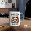White mug with a blue rim and handle, featuring a cartoon sloth holding a coffee cup and the text "BUSY DOING NOTHING".