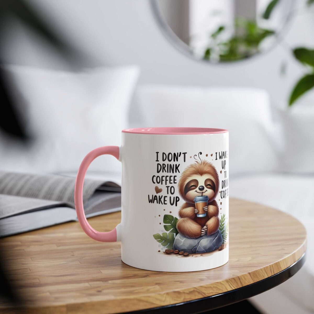 White ceramic mug with pink handle and rim, featuring a sloth graphic and text.