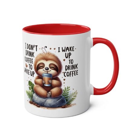 White ceramic mug with a red interior and handle, featuring a cute sloth holding a coffee cup with the text "I don't drink coffee to wake up. I wake up to drink coffee."