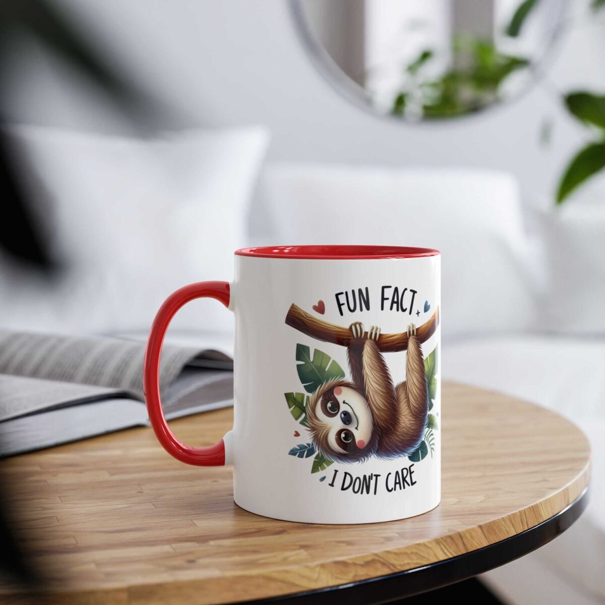 White ceramic mug with red handle and rim, featuring a cute sloth hanging from a branch with leaves and the text "FUN FACT, I DON'T CARE".