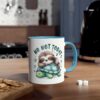A white coffee mug with a blue rim and handle, featuring a cute illustration of a sloth sleeping on a turtle.