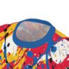 Red, yellow, blue, black, and white paint splatters cover this graphic streetwear tee, with bold strokes and drips creating an abstract art design.