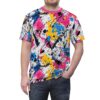 Crewneck t-shirt adorned with an energetic paint splatter design in pink, blue, yellow, and black on a white background.