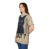 Tan fabric with a distressed texture covers this sublimation graphic tee, featuring a large black cat with wide eyes and fangs, text, and the word 