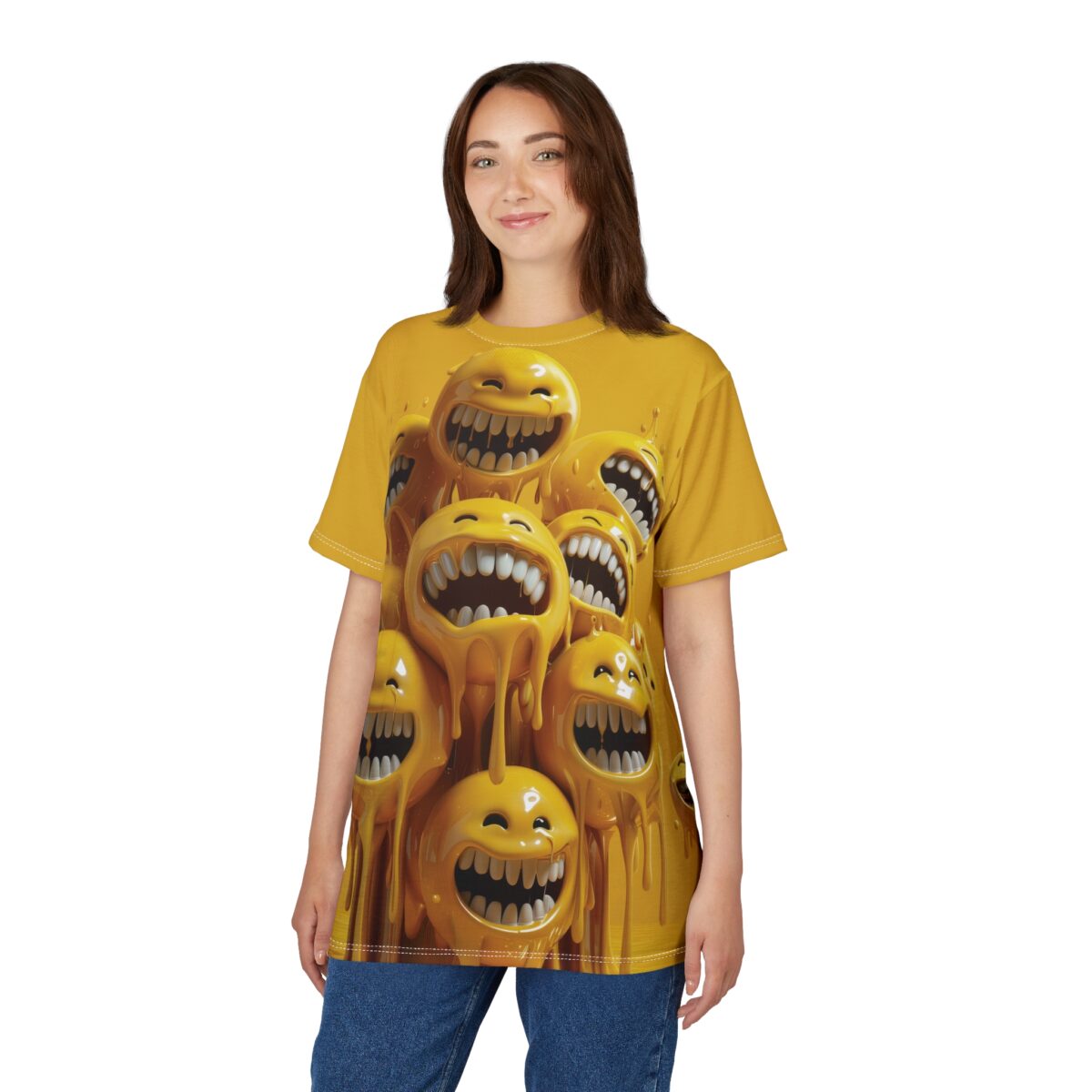 A young woman wearing a yellow t-shirt featuring a graphic of multiple melting, laughing yellow smiley faces. The smiley faces have wide mouths and sharp teeth, with yellow liquid dripping down from them. The woman is smiling and looking at the camera, wearing blue jeans. The background is white.