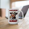 White ceramic mug with a grumpy cartoon cow eating a daisy and the text