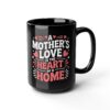 A black mug featuring white and pink text that reads 'A MOTHER'S LOVE IS THE HEART OF A HOME' with small heart and star accents.